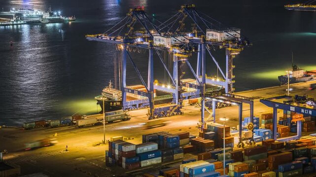 Night view time-lapse of container terminal working scene at Xiuying Port, Haikou, China, busy seaport crane logistics at night