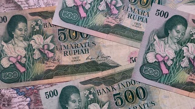 Close up video of vintage Indonesian 500 rupiah banknotes dated 1977, arranged in an overlapping composition.