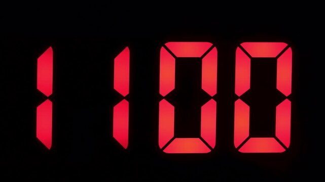 Red LED digital clock numbers illuminating the time 10:59 against a black background. Bright seven-segment digits create a clear and modern visual representation of time in hours and minutes format.