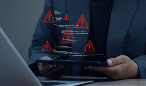 Programmer using digital tablet to find and fix bugs in software source code. Concept of debugging, system error warning, software development, and technical troubleshooting on laptop.