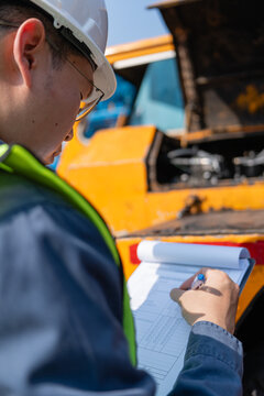 Crane safety inspection engineer checklist maintenance Worker hard hat performing crane safety inspection with clipboard checklist during