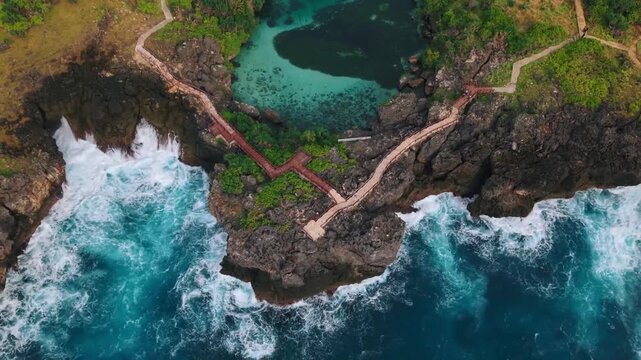 Aerial view of ocean waves crashing against rocky coastline