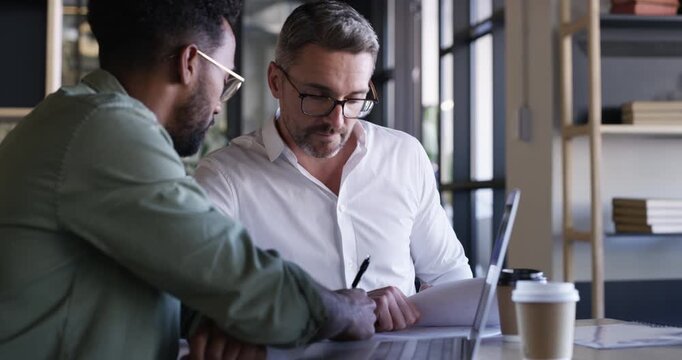 Business men, meeting monitoring and laptop with web design paperwork and mentor communication at desk. Teamwork, staff and graphic discussion in office with professional employee and work planning