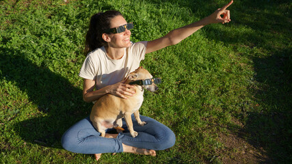 Woman and dog enjoying solar eclipse viewing together © Arianne