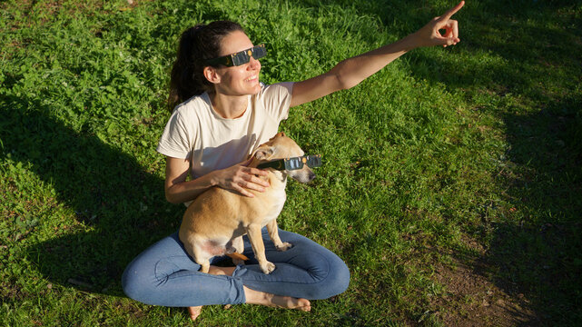 Woman and dog enjoying solar eclipse viewing together