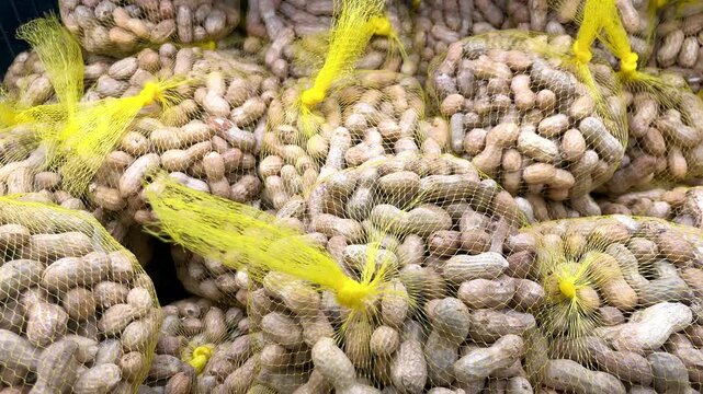 Fresh raw peanuts in yellow mesh bags