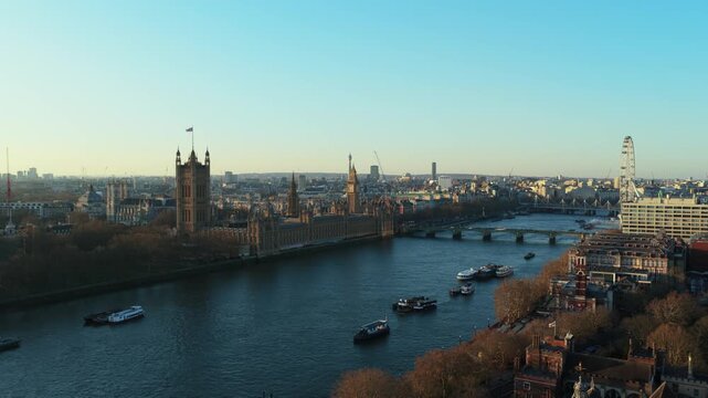 Elevated view from unique perspective of London skyline showing River Thames with boats, Westminster Palace, Big Ben, and London Eye during a sunny day