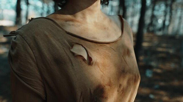 Cinematic Scene of Woman in Torn Clothes in Dark Natural Wilderness
