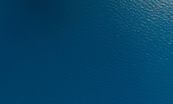 Aerial view of deep blue ocean water with shimmering highlights