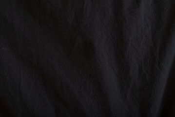 Fototapeta premium This scene features a dark fabric surface with a soft texture that displays subtle folds and shadows