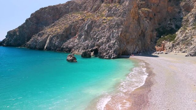 Crete Greece 4k aerial drone low flight over Agiofarango beach turquoise water. Scenic view of wild rocky coast with cliffs emerging from sea in South Crete. Authentic Mediterranean nature landscape