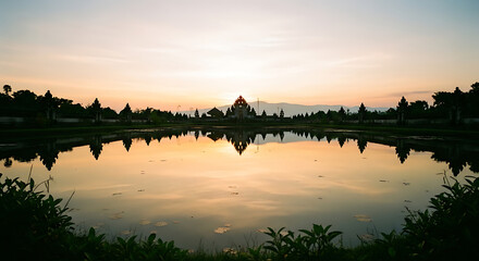 Naklejka premium Traditional Balinese water temple at sunrise with golden sky reflection