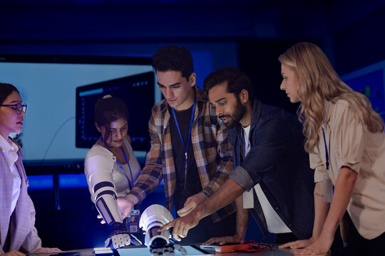 A startup team develops future medical technology. The diverse engineers test a new AI robotic prosthetic, an innovative solution for healthcare and digital transformation.