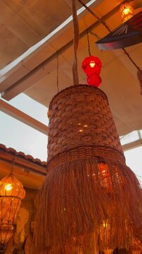 Interior view of a cozy restaurant with decorative hanging lamps. The ceiling features a glass panel allowing natural light to enter.