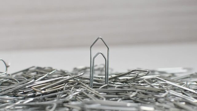 Paper clips intertwined in chaos on a bright surface, a visual representation of disordered creativity.