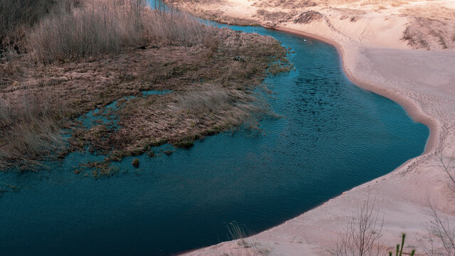 Sandy dunes and river flowing into sea Baltic coast natural landscape.Balta Kapa.Latvia