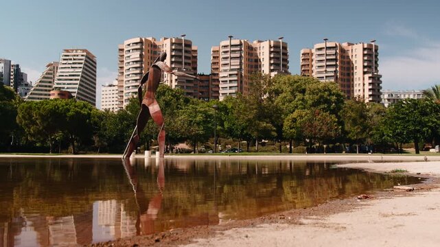 Valencia cityscape with modern sculpture reflection in turia garden pond
