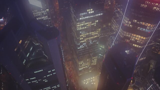 Aerial footage showing Omniturm and illuminated skyscrapers of Frankfurt's financial district at night including Commerzbank Tower and Trianon