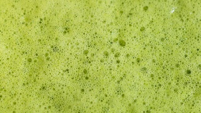 Close up of matcha texture with creamy foam and bubbles. Drink backgorund