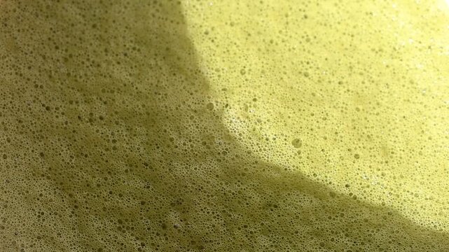 Close up of matcha texture with creamy foam and bubbles. Drink background