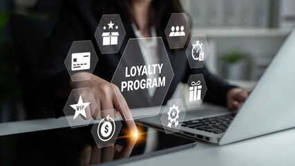Naklejka premium A businessperson interacts with a laptop showcasing a digital loyalty program interface, symbolizing customer engagement and innovative business strategies for enhancing user experiences. Ledger
