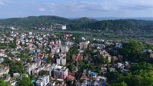 An aerial view of urban residential flats and densely built neighbourhood spread across lush green hills in Guwahati, reflecting the city&rsquo;s growing apartment culture alongside natural landscapes