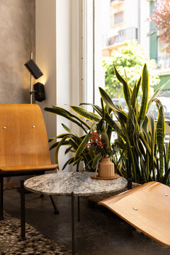 Low seating at a hip city cafe next to window with plant decor and natural light