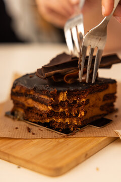 close up depth of field of fork cutting into rich decadent layered chocolate cake in a restaurant