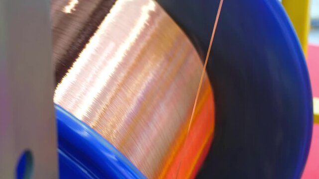 Moscow. Russia, 11.03.2026 Copper wire winding process on industrial spool. Metal cable production in factory. Manufacturing equipment for electrical conductor wrapping and coil winding task.
