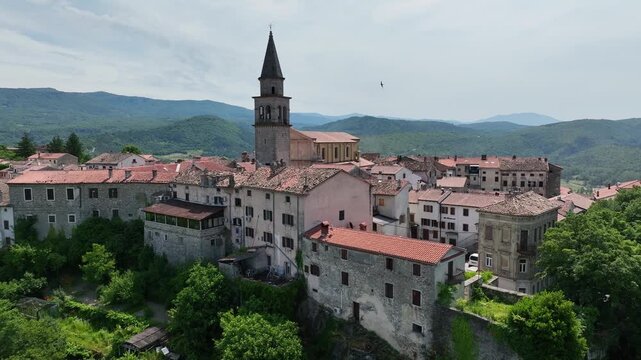 Aerial drone view of Buzet historic medieval town in Istria Croatia at early summer showing old stone buildings, hilltop settlement, surrounding forests and green valley landscape