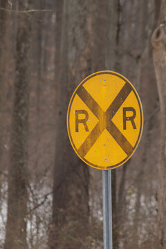 A small railroard crossing sign for a miniature train at a park 