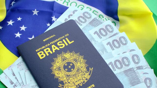 Version 1: Brazilian passport on the national flag and 100 real bills. Symbols of Brazil's identity and prosperity.