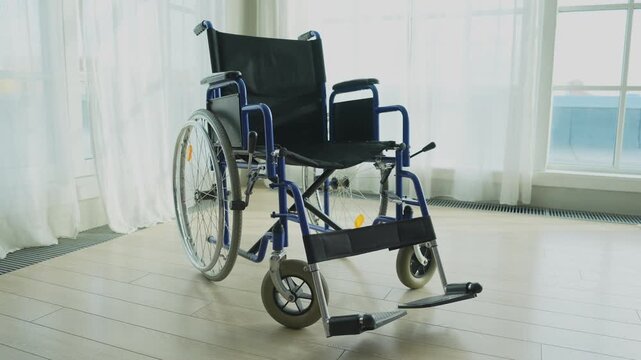 Empty wheelchair waiting for patient services in living room retirement home hospital. Chair for people with disability at home. Handicap accessible symbol. Health care medical lonely elderly sick