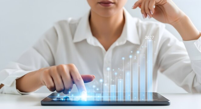 Person analyzing financial data and growth projections on a tablet with glowing blue chart.