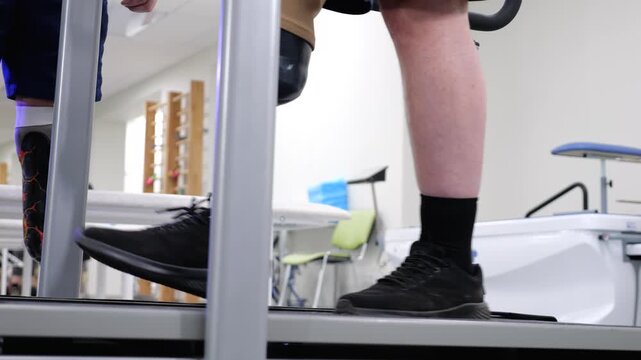Amputee with prosthetic leg walking on treadmill during rehabilitation