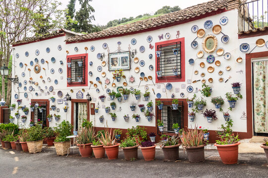vivienda tipica del Sacromonte con muchas macetas con plantas y objetps de decoraci&oacute;n y motivos religiosos en su fachada, Granada, Espa&ntilde;a