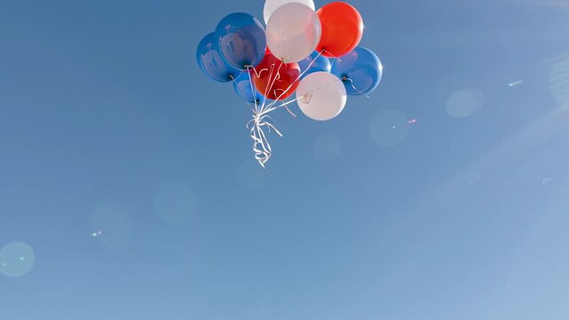 Red white and blue balloons floating in blue sky, festive American Independence Day celebration background with copy space
