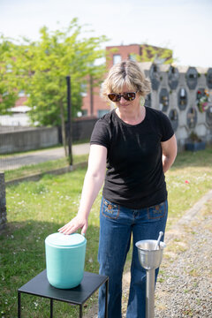 Woman paying respects at columbarium cemetery Tienen