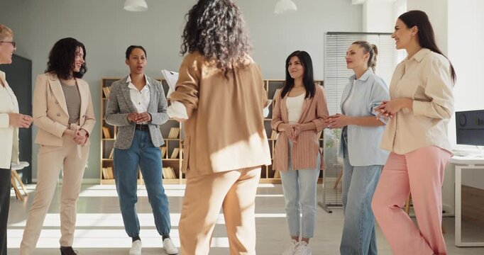 Women team training workshop office meeting discussion. Professionals stand in a bright workspace sharing ideas and practicing leadership skills. Clear concept of teamwork and coaching.