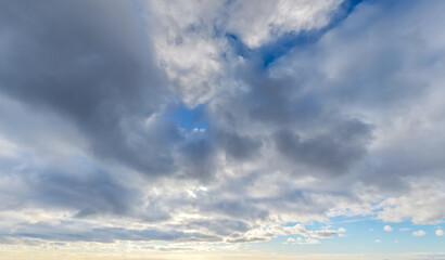 Fototapeta premium Dramatic Cloudscape Overcast Sky With Blue Patches and Soft Sunlight on the Horizon