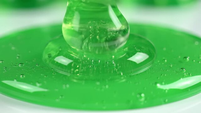 Closeup of vibrant green slime dripping and forming a pool.