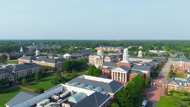 Christopher Newport University campus, a sweeping aerial drone view showcasing the grand neoclassical brick architecture, iconic golden domes, and manicured green lawns of the CNU campus in Newport Ne