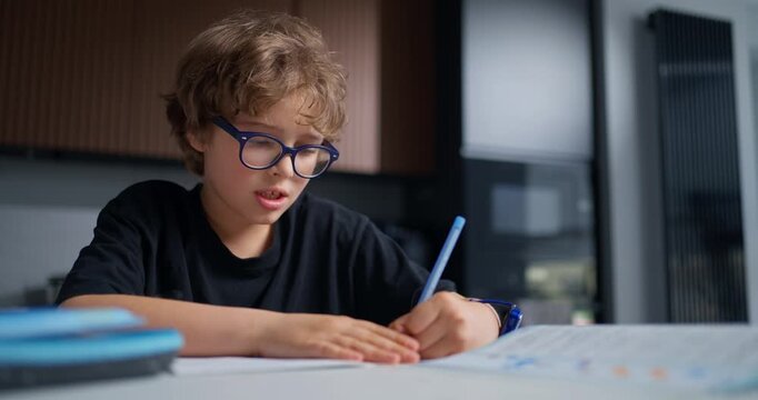 Student Concentrating Carefully On Assignments With Scattered Supplies And Focused Determination Across Desk
