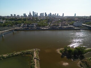 Warszawa - Polska - panorama Warszawy wykonana dronem. Rzeka Wisła, kościół, wieżowce, bloki, ulice w słoneczny dzień © Konrad