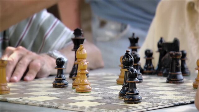 Senior Man Hand Crowning A Black Pawn During Chess Game In The Park - 4K