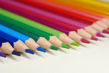 Fototapeta premium New wooden colored pencils of rainbow colors, perfectly sharpened, lie on table