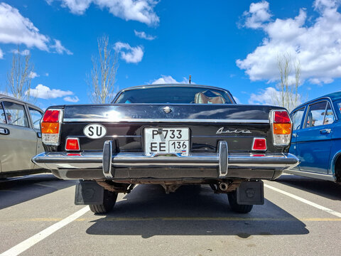 VORONEZH, Russia - April 25, 2026.Low angle shot of a black retro GAZ Volga with a vintage SU sticker parked in a lot under a blue sky and white clouds