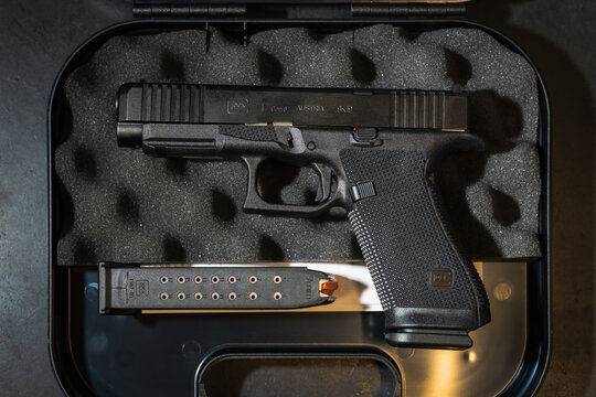 TALLINN, ESTONIA - MAY 5, 2026: An overhead view of a brand new Glock 17 Gen6 9mm pistol in its factory hard case with a spare magazine and foam liner, showing its unique Gen6 markings and textures.