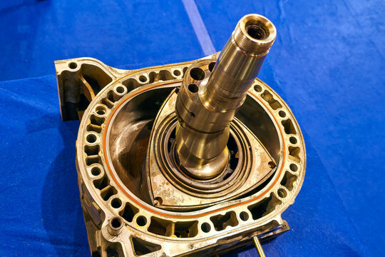 Rotary engine housing with eccentric shaft and rotor assembly detail on workshop table surface