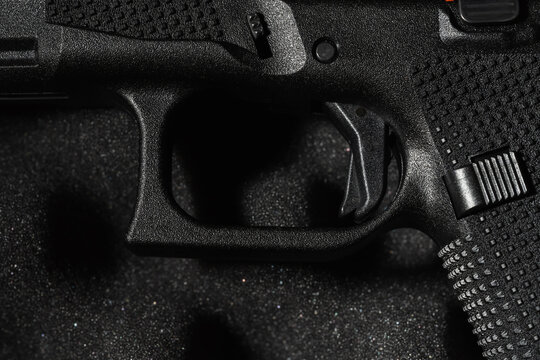 BALTIC STATES - MAY 4, 2026: Macro detail of the new flat trigger and magazine release on a sixth generation Glock pistol
